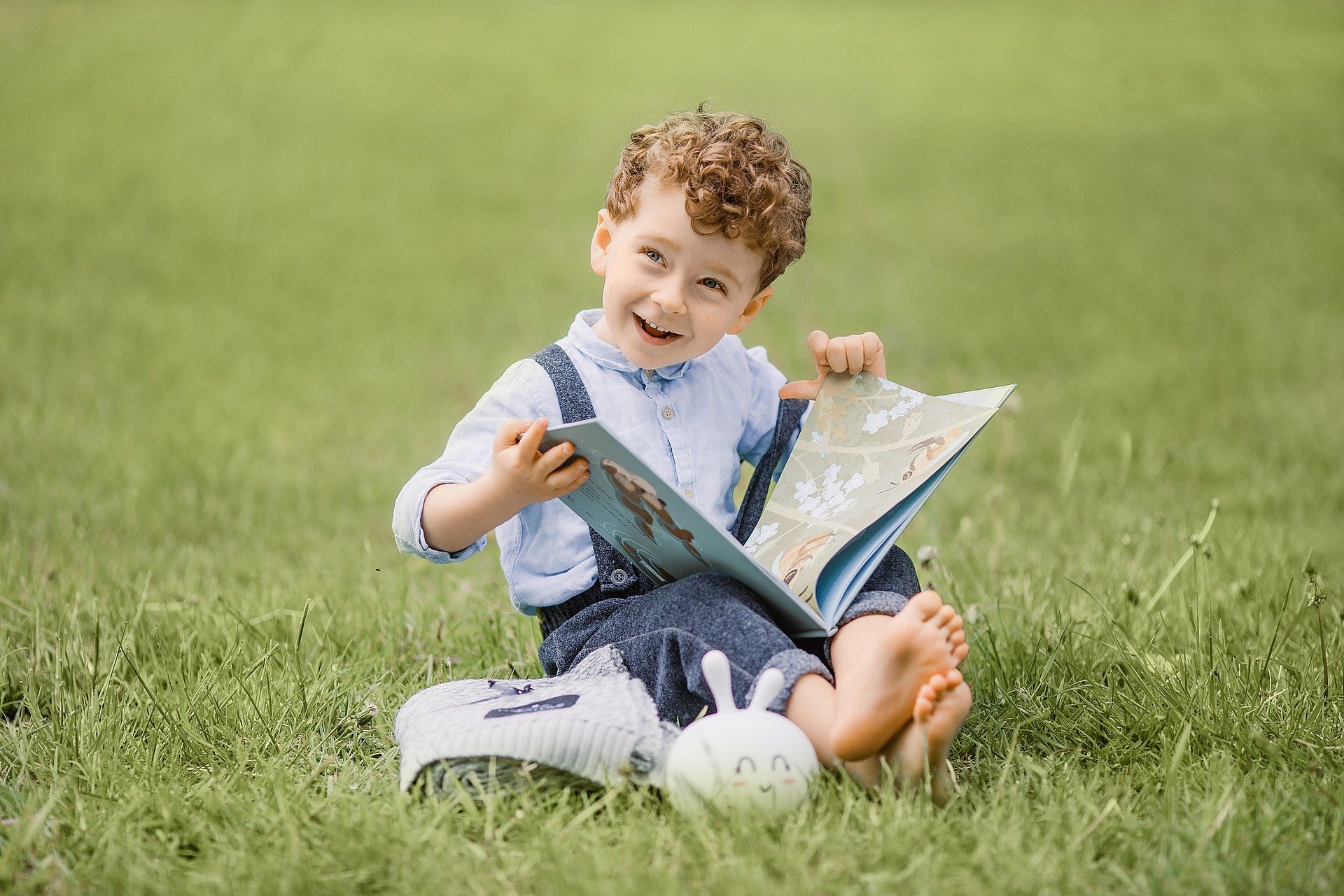 Little boy smiling while looking at a picture book
