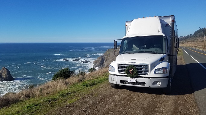 Bookmobile with Front Wreath parked by the ocean.