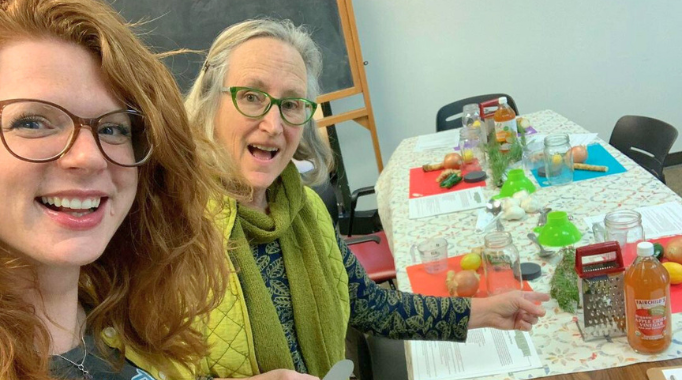 Librarians making cider at a library event.