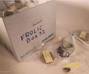Photo of a banker box labeled "Frolic Box 22" - the box is filled with plastic bags containing blue and white pottery sherds.