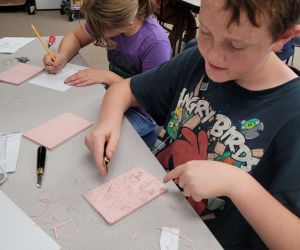 Two children are drawing at a table.