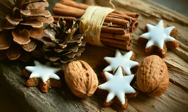Holiday cookies, walnuts, and cinnamon on a board.
