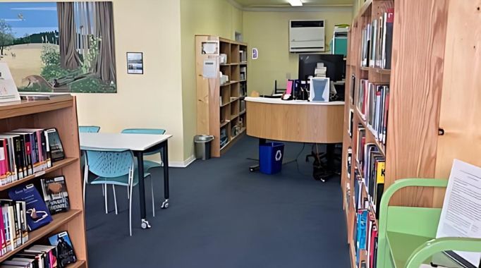 Bookshelves and table with front desk at the Laytonville Library.