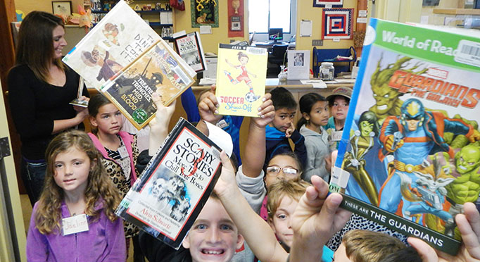 Children holding up books at the Fort Bragg Library.
