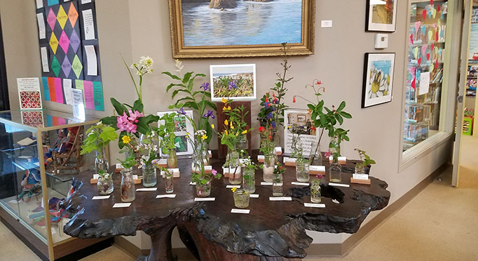 Flowers in vases on display at the Fort Bragg Library.